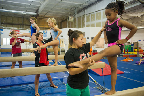 Xacha Williams (right) receives instruction on the balance beam from camp coach Stacy Scobel as Evelyn Rosselot is helped by Angelica Gillott and Phoebe Close is helped by Paula Nation during summer gymnastics camp at the Atlanta Gymnastics Center in Decatur on Tuesday, June 5, 2012. Gymnastics camp started May 29 and runs each week, Monday through Friday, until August 15.